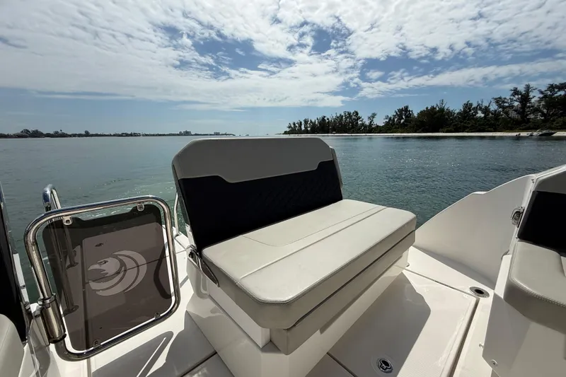 Slide: The Image of Aquila 32 Sport 2025 boat with seating, overlooking serene water and distant shoreline. - 19
