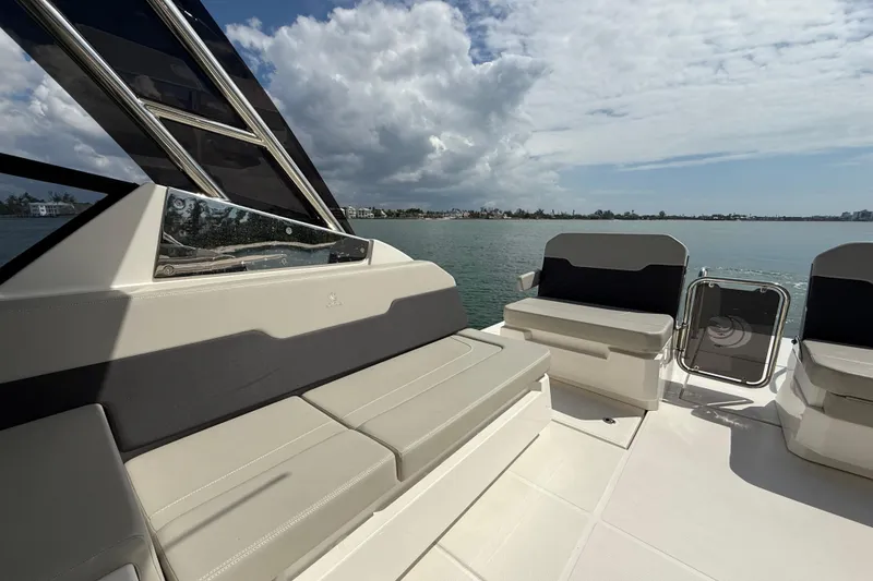 Slide: The Image of Aquila 32 Sport 2025 boat interior with seating, overlooking calm waters and cloudy sky. - 22