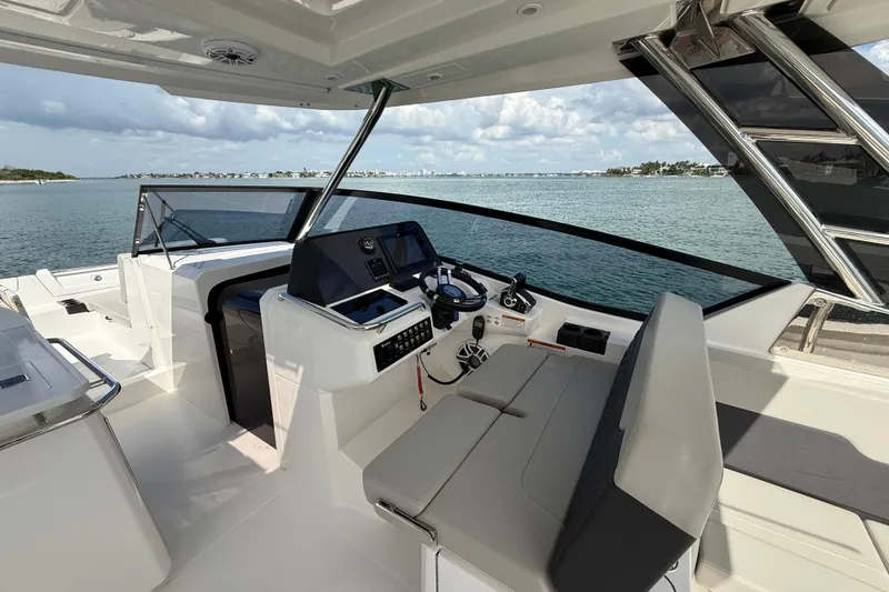 Slide: The Image of Aquila 32 Sport 2025 boat interior with helm, seating, and ocean view. - 27