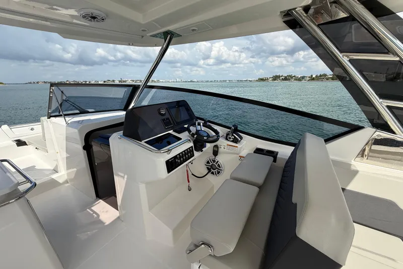 Slide: The Image of 2025 Aquila 32 Sport yacht helm with modern controls, overlooking serene waters. - 28