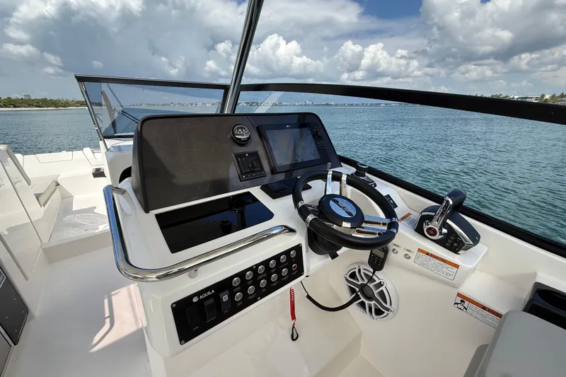 Slide: The Image of Helm of 2025 Aquila 32 Sport boat with modern controls and scenic ocean view. - 29