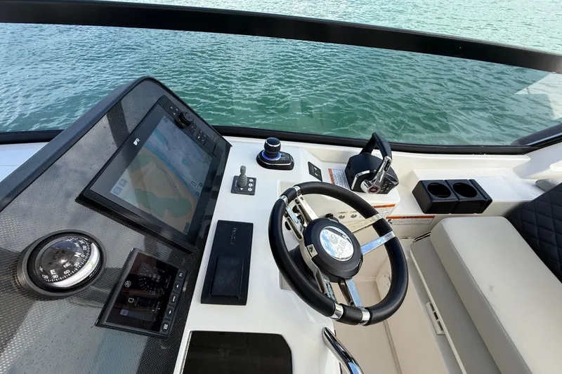 Slide: The Image of Helm of 2025 Aquila 32 Sport boat with navigation controls and steering wheel. - 30