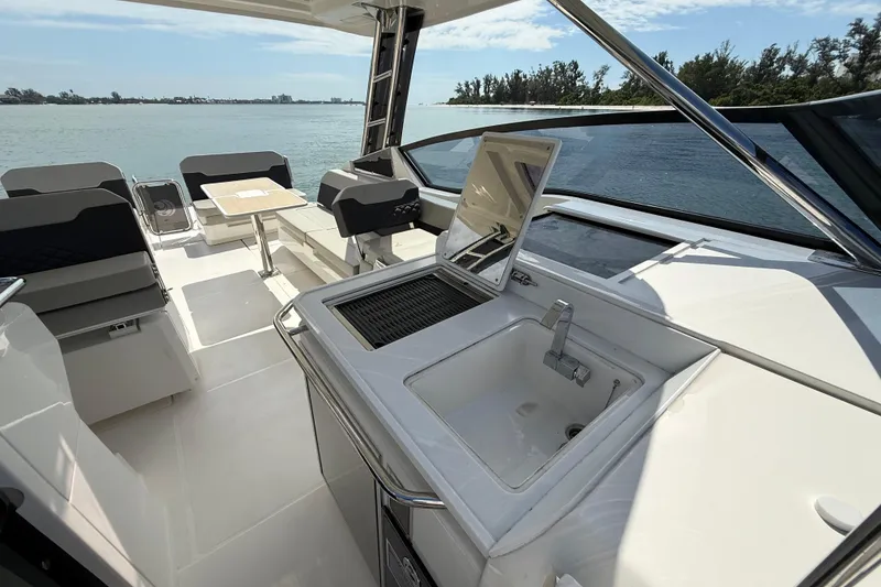 Slide: The Image of Aquila 32 Sport 2025 yacht interior with sink and seating area, overlooking serene waters. - 35