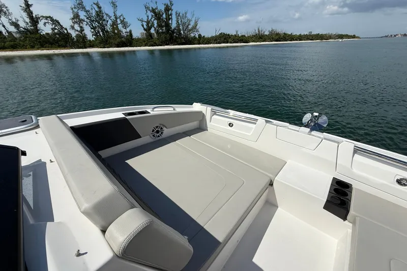 Slide: The Image of 2025 Aquila 32 Sport boat interior with seating, on calm water near a tree-lined shore. - 41