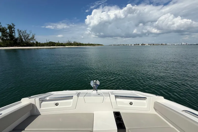 Slide: The Image of Aquila 32 Sport 2025 boat on calm water with scenic coastal view. - 42