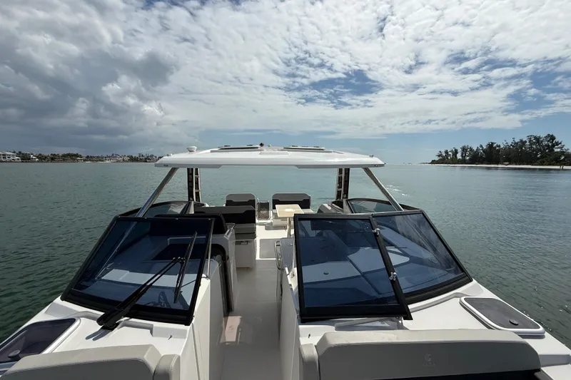 Slide: The Image of Aquila 32 Sport 2025 cruising on calm waters under a partly cloudy sky. - 44