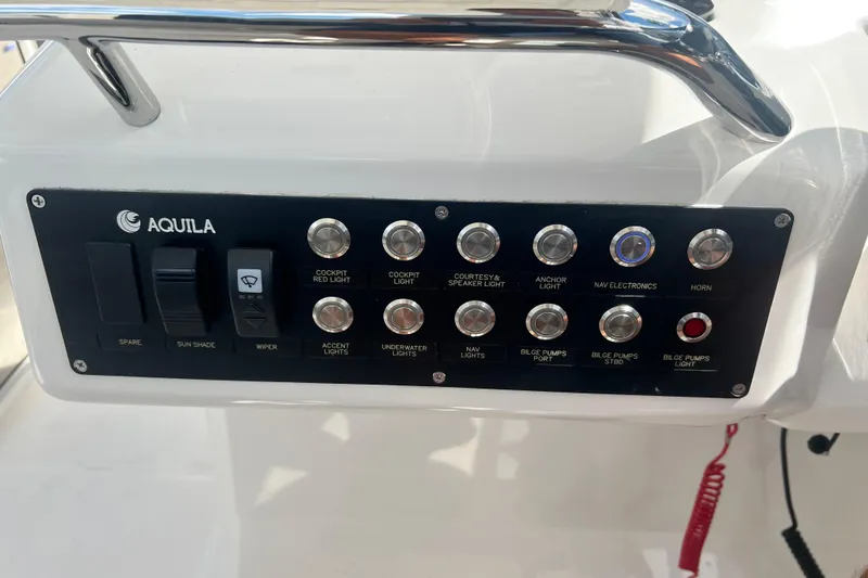 Slide: The Image of Control panel of 2025 Aquila 32 Sport boat with various switches and buttons. - 49