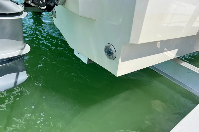 Slide: The Image of Aquila 32 Sport 2025 boat stern with outboard motor in green water. - 52