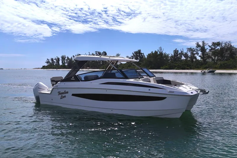 Slide: The Image of Aquila 32 Sport 2025 boat cruising on a sunny day near a scenic shoreline. - 6