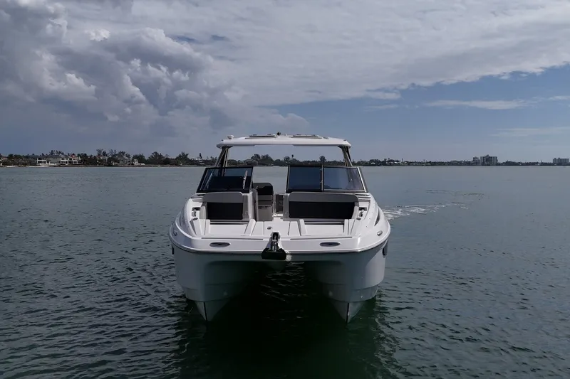 Slide: The Image of 2025 Aquila 32 Sport boat on calm water under cloudy sky. - 7
