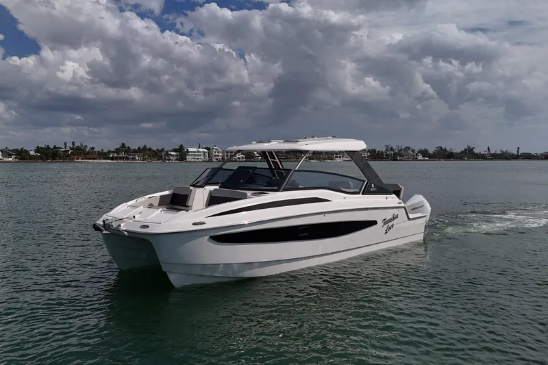 Slide: The Image of 2025 Aquila 32 Sport boat on calm water under cloudy sky. - 8