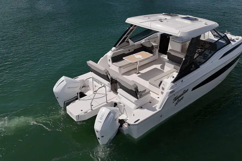 Slide: The Image of 2025 Aquila 32 Sport boat with dual Mercury engines on calm water. - 9