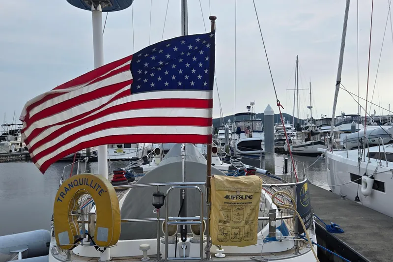 Slide: The Image of Swan 46 sailboat from 1985 with American flag in marina setting. - 37