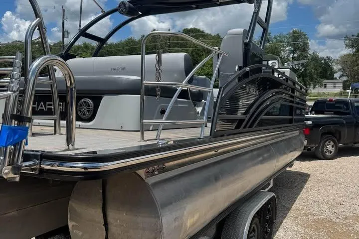 Slide: The Image of 2020 Harris Solstice 250 pontoon boat on trailer, parked outdoors under a cloudy sky. - 3