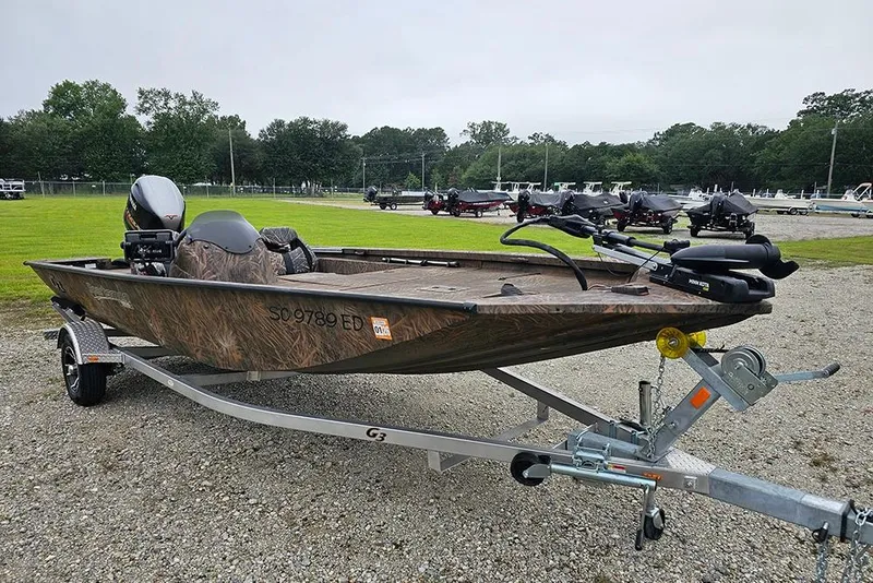 Slide: The Image of 2023 G3 Sportsman 1810 Camo boat on trailer, parked outdoors. - 1
