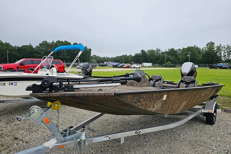 Slide: The Image of 2023 G3 Sportsman 1810 Camo boat on trailer, parked outdoors. - 4