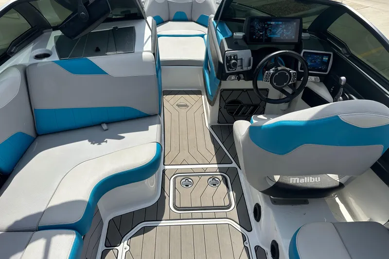 Slide: The Image of 2018 Malibu Wakesetter 23 LSV interior with blue and gray seating, modern dashboard, and steering wheel. - 11