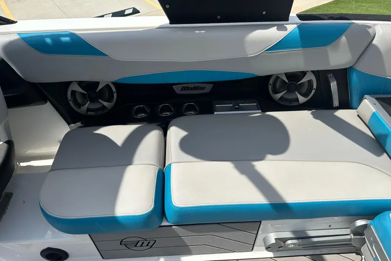 Slide: The Image of 2018 Malibu Wakesetter 23 LSV interior with blue and gray seating, featuring speakers and cup holders. - 13