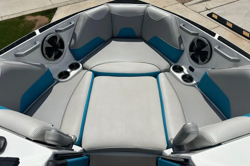 Slide: The Image of 2018 Malibu Wakesetter 23 LSV boat interior with gray and blue seating, cup holders, and speakers. - 14
