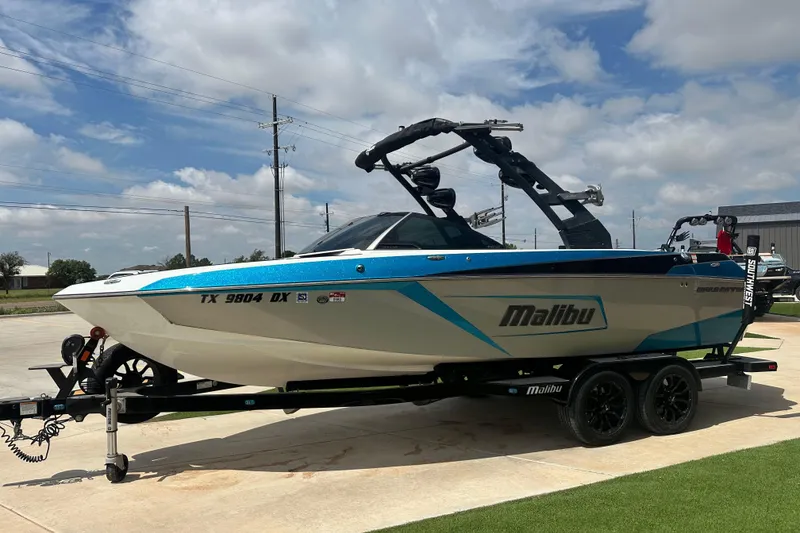 Slide: The Image of 2018 Malibu Wakesetter 23 LSV boat on trailer, parked outdoors under a cloudy sky. - 6