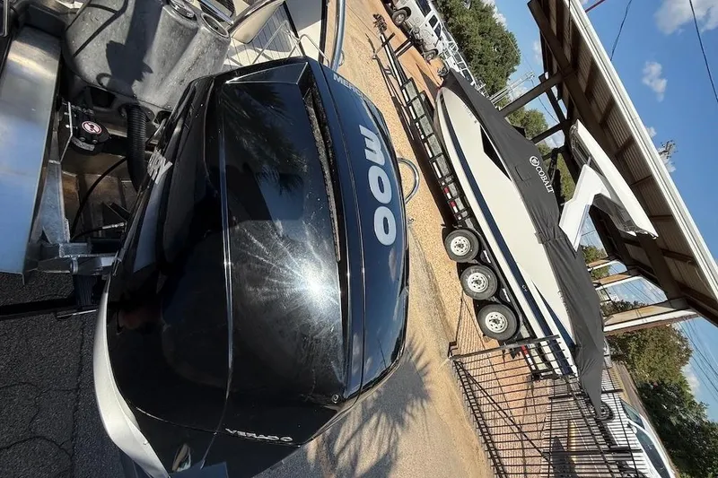 Slide: The Image of 2021 Barletta L23UC boat with Mercury engine, parked near a covered trailer. - 16