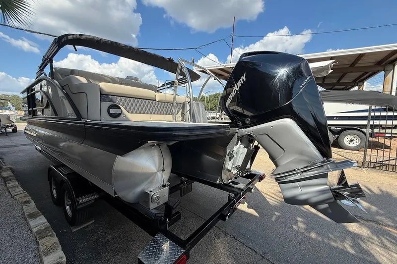 Slide: The Image of 2021 Barletta L23UC pontoon boat with Mercury outboard motor, parked on a trailer. - 4
