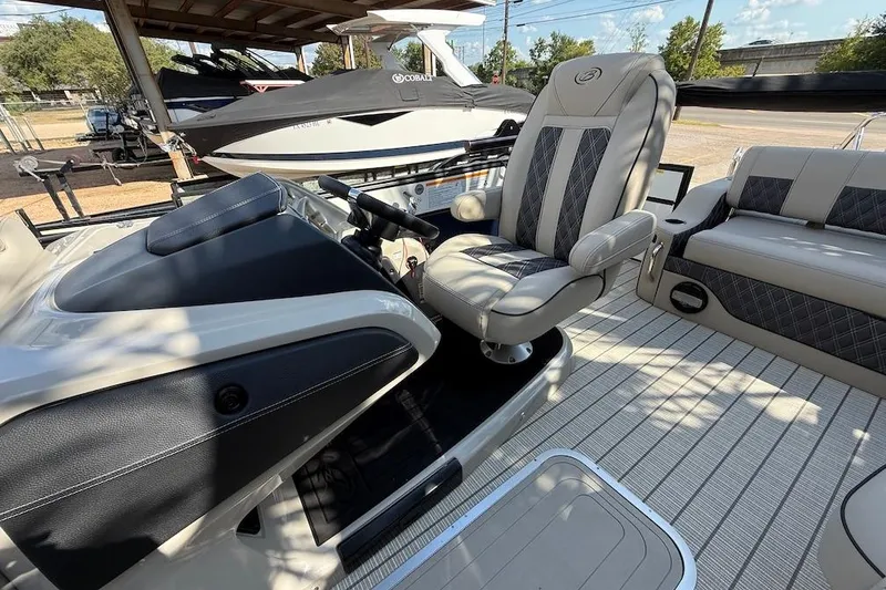 Slide: The Image of 2021 Barletta L23UC boat interior with captain's chair and dashboard, showcasing luxury seating. - 7