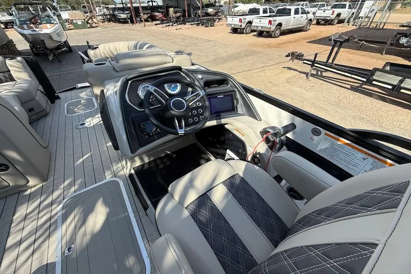 Slide: The Image of 2021 Barletta L23UC boat interior with steering console and seating, parked outdoors. - 8