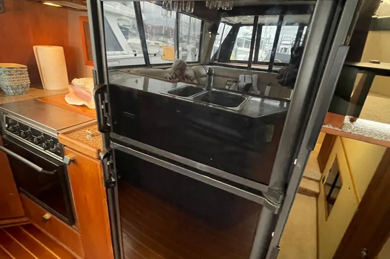 Slide: The Image of 1989 Bayliner Pilothouse 4588 kitchen with stove, refrigerator, and sink. - 10