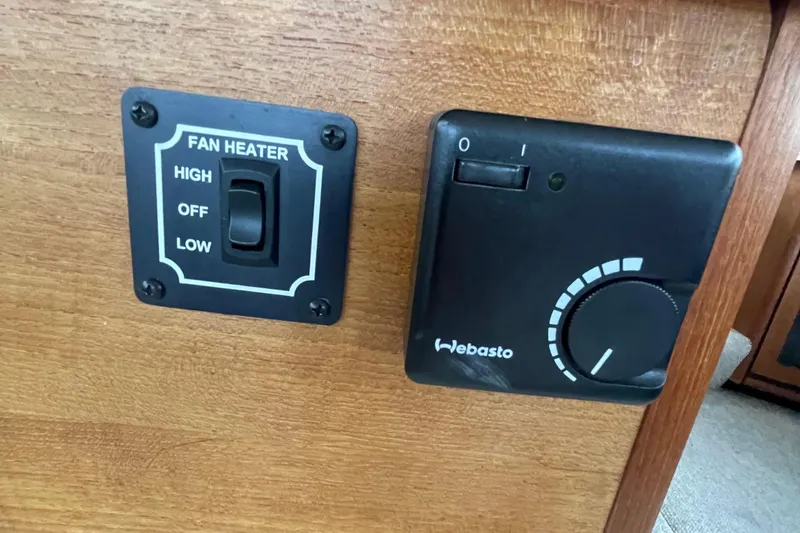 Slide: The Image of 1989 Bayliner Pilothouse 4588 fan heater and Webasto control panel on wooden surface. - 12