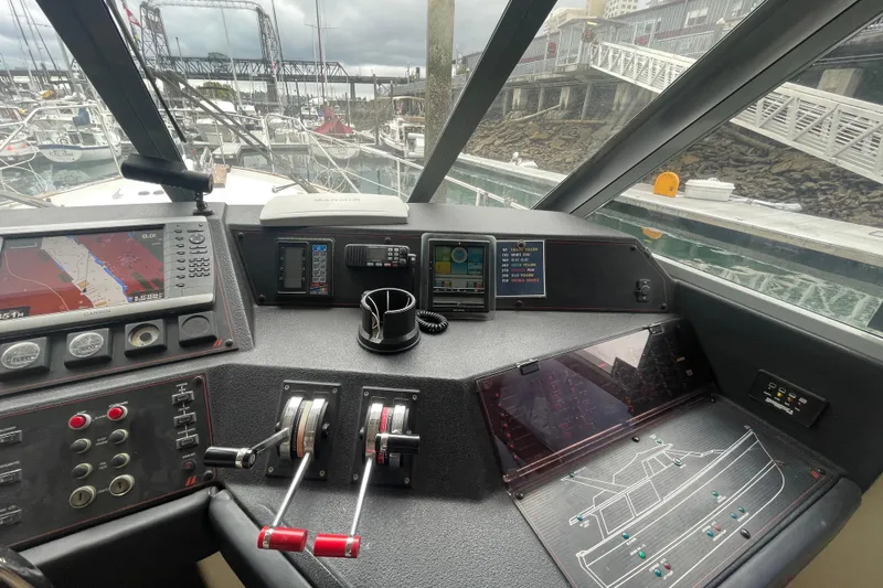 Slide: The Image of 1989 Bayliner Pilothouse 4588 helm with navigation equipment and marina view. - 19