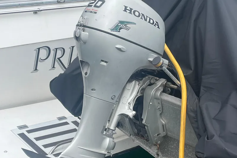 Slide: The Image of Honda outboard motor on a 1989 Bayliner Pilothouse 4588 boat, partially covered. - 2