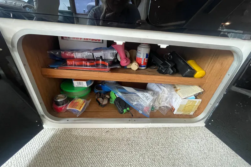 Slide: The Image of Storage compartment on a 1989 Bayliner Pilothouse 4588, filled with various boating supplies. - 21