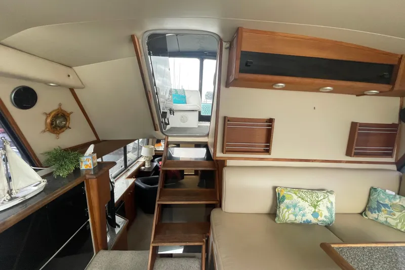Slide: The Image of Interior of 1989 Bayliner Pilothouse 4588 with stairs, seating, and nautical decor. - 26
