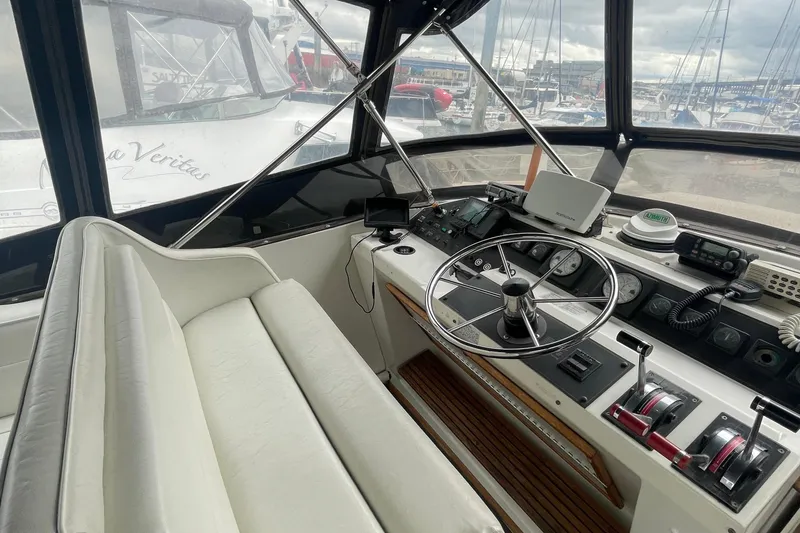 Slide: The Image of 1989 Bayliner Pilothouse 4588 helm with steering wheel, controls, and navigation equipment. - 28