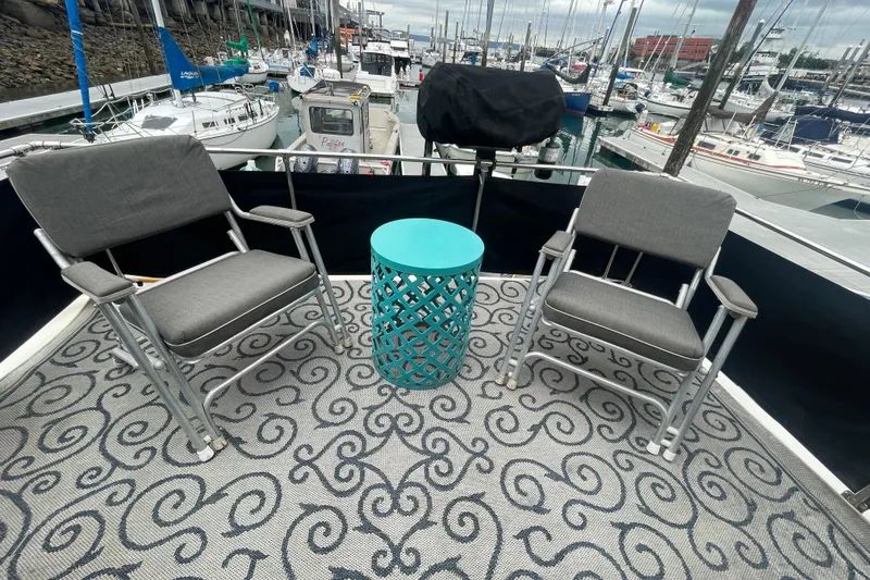 Slide: The Image of 1989 Bayliner Pilothouse 4588 deck with chairs and turquoise table, marina view. - 29