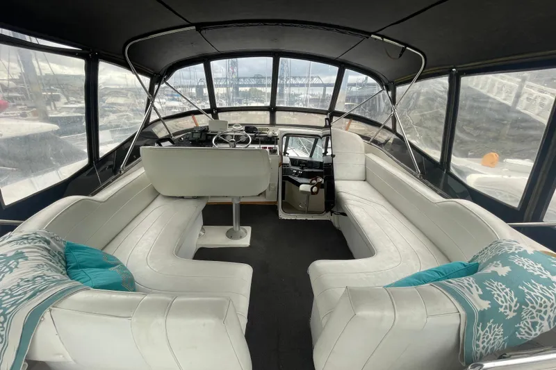 Slide: The Image of 1989 Bayliner Pilothouse 4588 interior with white seating and turquoise pillows. - 30