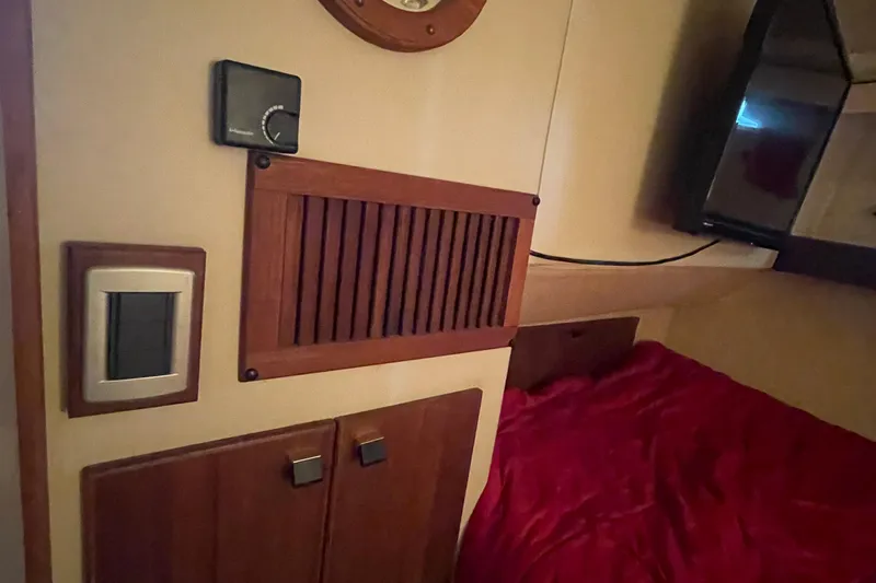 Slide: The Image of Interior of 1989 Bayliner Pilothouse 4588 with wood paneling and red bedding. - 33