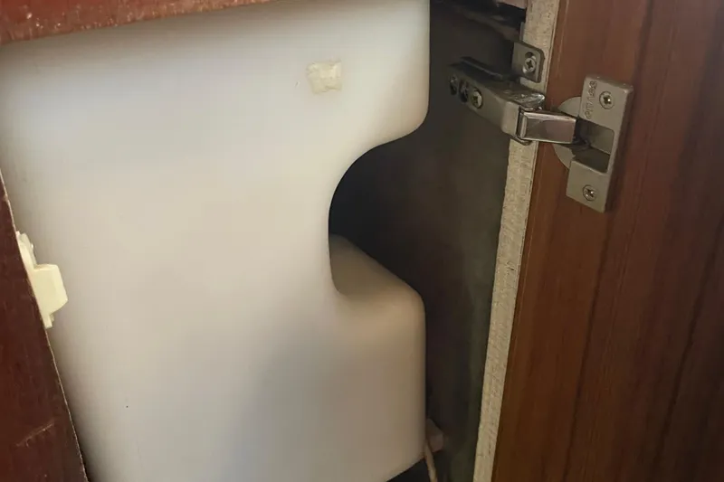 Slide: The Image of 1989 Bayliner Pilothouse 4588 interior cabinet with white plastic container. - 37