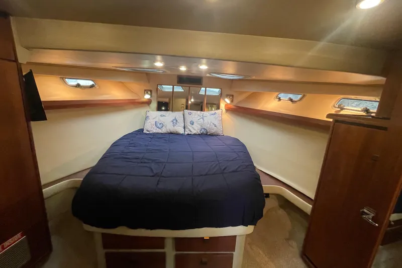Slide: The Image of Cozy bedroom in 1989 Bayliner Pilothouse 4588 yacht with blue bedding and wooden accents. - 38