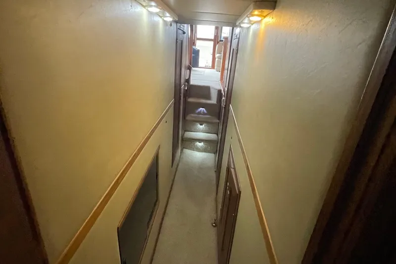 Slide: The Image of Narrow hallway inside 1989 Bayliner Pilothouse 4588 yacht, featuring carpeted stairs and ambient lighting. - 42