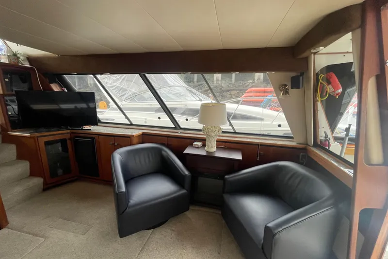 Slide: The Image of Interior of 1989 Bayliner Pilothouse 4588 with seating, TV, and large windows. - 7