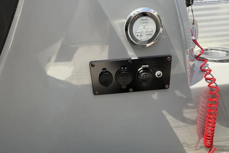 Slide: The Image of Control panel of 2021 Godfrey Monaco 235 SFL GTP boat with power outlets and red coiled cord. - 16