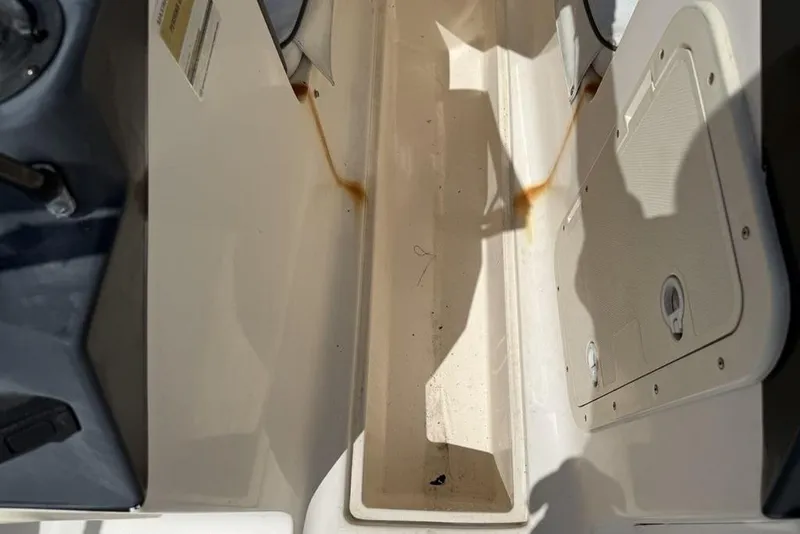 Slide: The Image of 1994 Seaswirl 192 Striper boat interior with storage compartment and visible rust stains. - 17