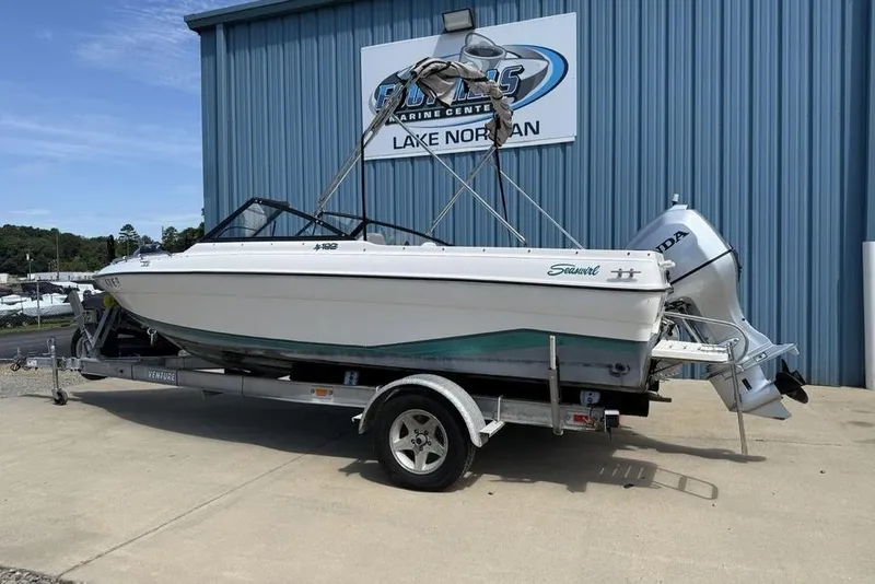 Slide: The Image of 1994 Seaswirl 192 Striper boat on trailer, parked outside marine center. - 3