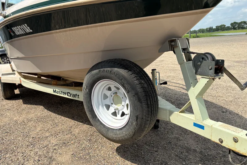 Slide: The Image of 1999 MasterCraft 205 PRO STAR boat on trailer, close-up of wheel and hull. - 17