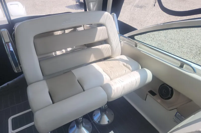 Slide: The Image of 2018 Boston Whaler 320 Vantage boat seat with beige upholstery and chrome accents. - 11