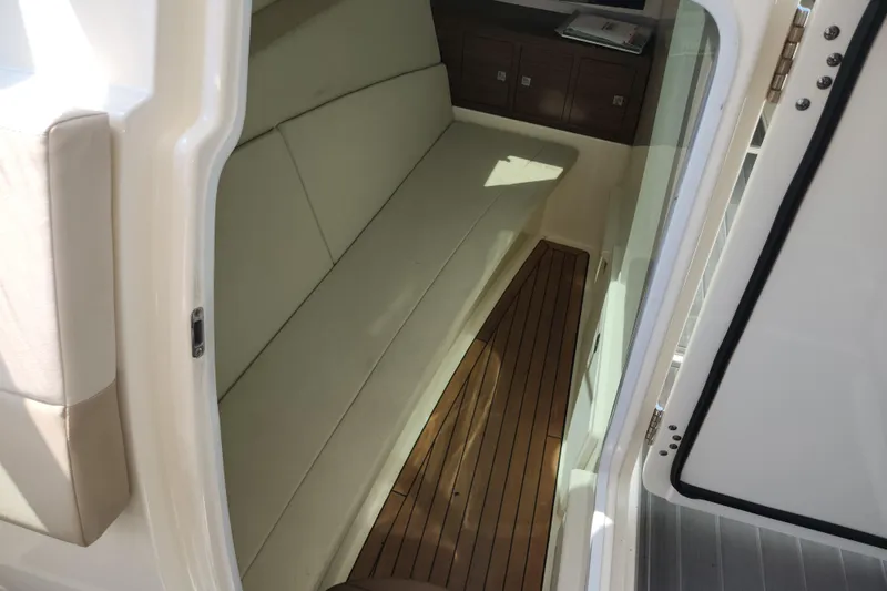 Slide: The Image of Interior view of 2018 Boston Whaler 320 Vantage with cushioned seating and wooden flooring. - 12