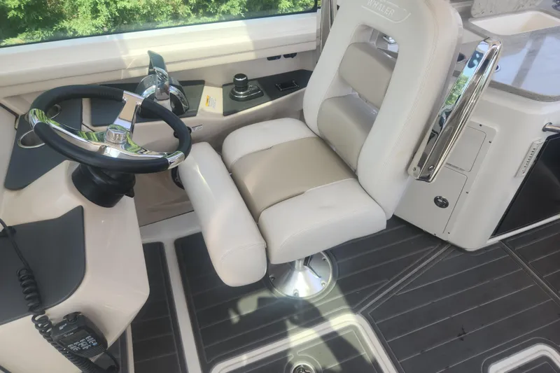 Slide: The Image of 2018 Boston Whaler 320 Vantage helm with steering wheel and captain's chair. - 13