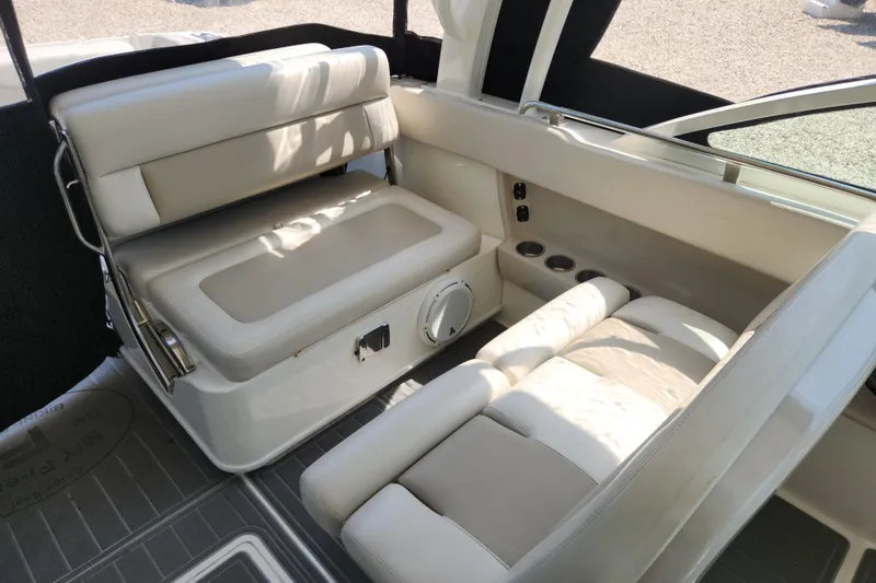 Slide: The Image of 2018 Boston Whaler 320 Vantage interior seating with beige upholstery and cup holders. - 9